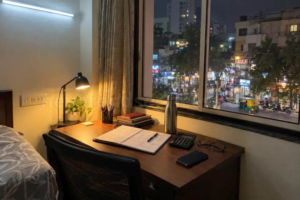 A service apartment desk in BTM Layout at night with a business diary and calculator